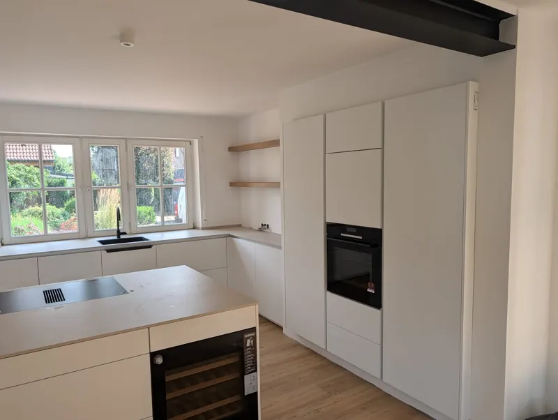 Weiße Küche mit Weinkühlschrank in der Kochinsel