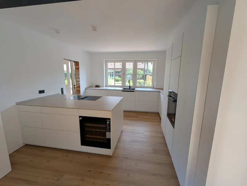 Küche mit Kochinsel, Weinkühlschrank und Blick in den Garten