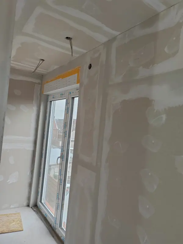 Spachtelstellen an Wand und Decke neben einer Balkontür