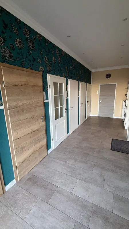 Flur mit weißen Türen und Holzverkleidung