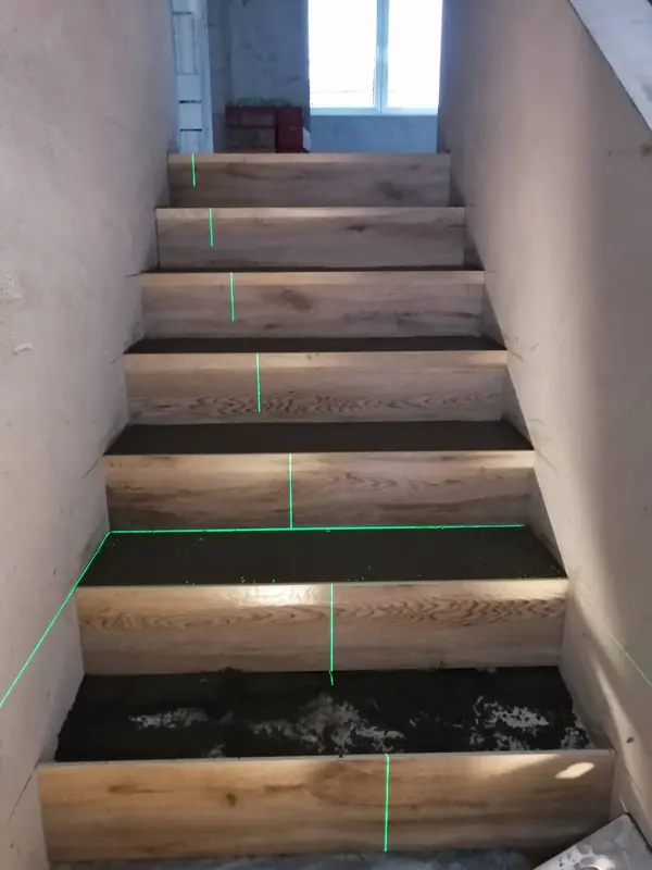 Treppe mit Stufen in Eichenoptik und grünen Laserlinien
